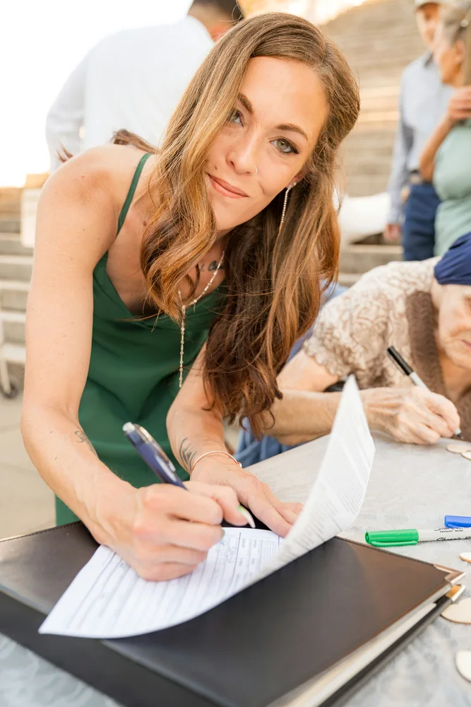 Signer completing a formal document at a table